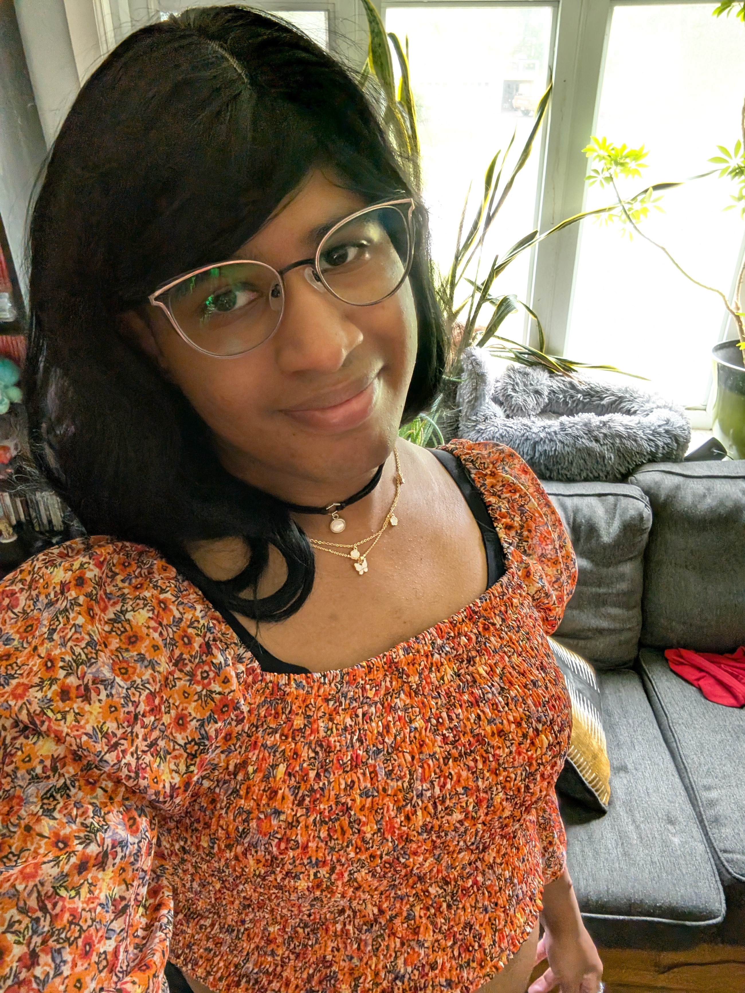 A cutie patootie rocking an orange crop, cats eye glasses, a choker and butterfly necklace